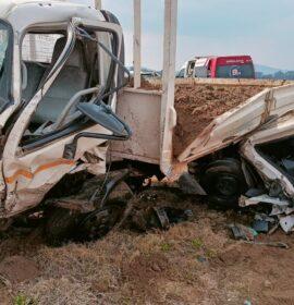 Small bakkie found on its roof under a delivery truck carrying a load of sand